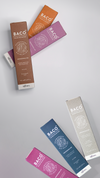 Four colorful cosmetic tubes arranged on a light gray background