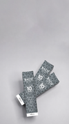 Two dark product sachets on a light gray background