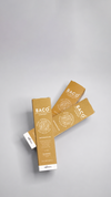 Two gold product sachets on a light gray background