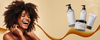 Smiling Black woman with curly hair beside white pump products