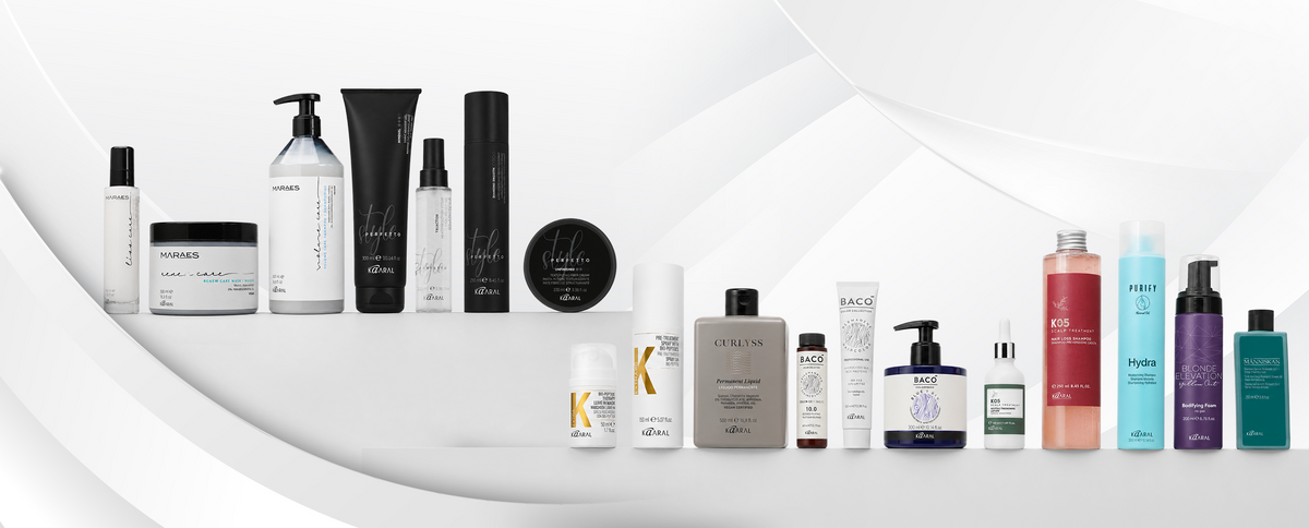 Assorted Kaaral haircare and styling products arranged on a white curved display