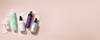 Assorted pastel product bottles on a pale pink banner