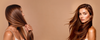 Two women with long, smooth brown hair against a warm beige background, one holding her hair to highlight its length and the other facing forward with flowing, glossy hair.