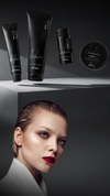 Kaaral Perfetto hair styling products above a woman with slicked-back hair on a dark background